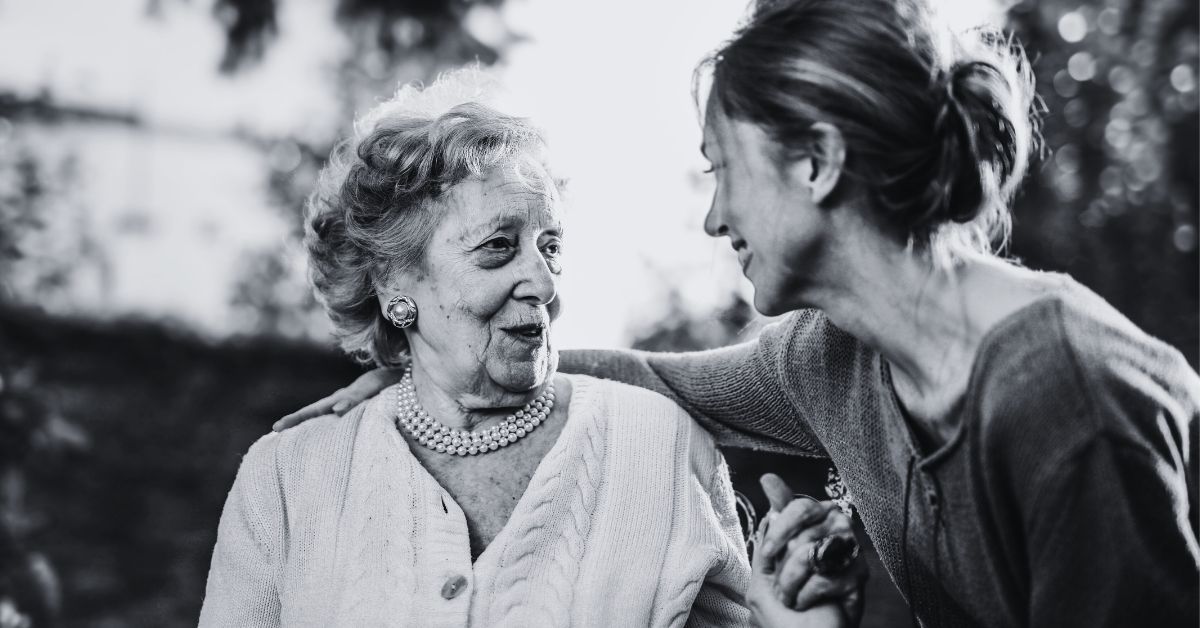 Woman caring for elderly woman black and white